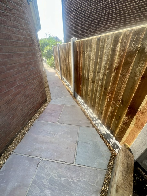 Featheredge board fencing with raj sandstone walkway