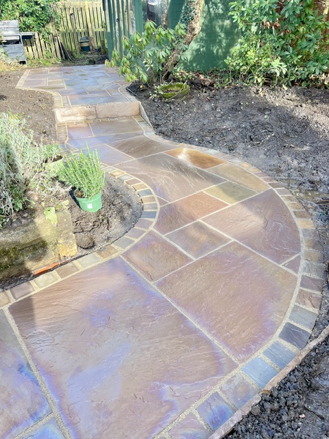 Raj Indian sandstone curving path edged with matching square setts Raj Indian sandstone curving path edged with matching square setts
