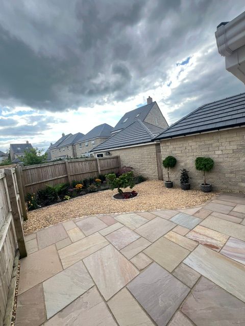 Curved Raj indian sandstone patio in mixed sizes, edged with matching cobbles Curved Raj indian sandstone patio in mixed sizes, edged with matching cobbles